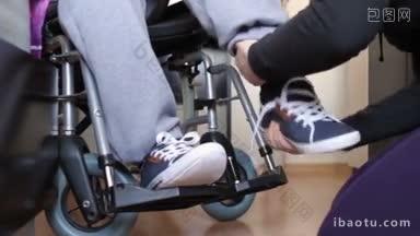 帮助轮椅上的残疾青年穿衣服